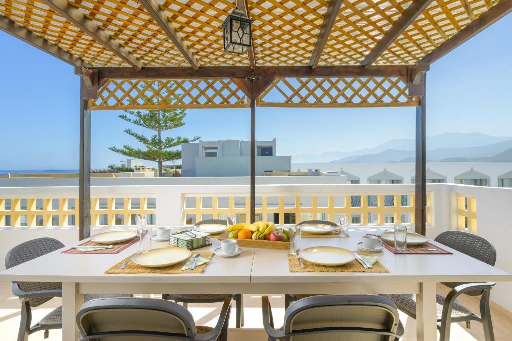 un tavolo bianco con sedie sul balcone di Aris Studios a Hersonissos