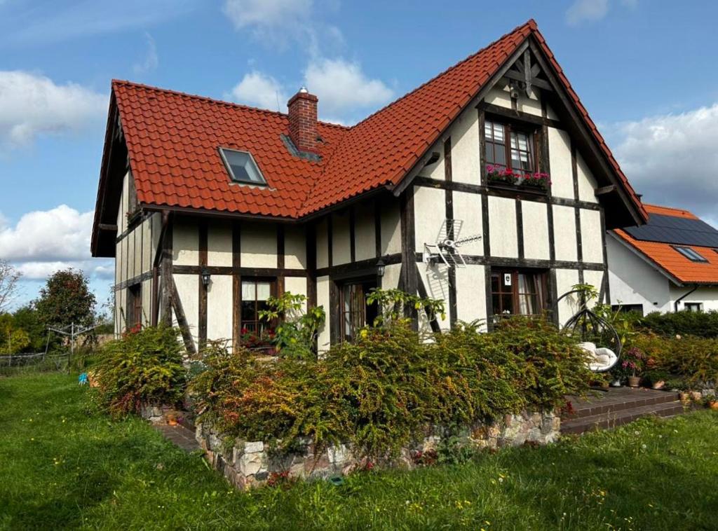 ein schwarzweißes Haus mit rotem Dach in der Unterkunft Rumiankowa Bis in Puck