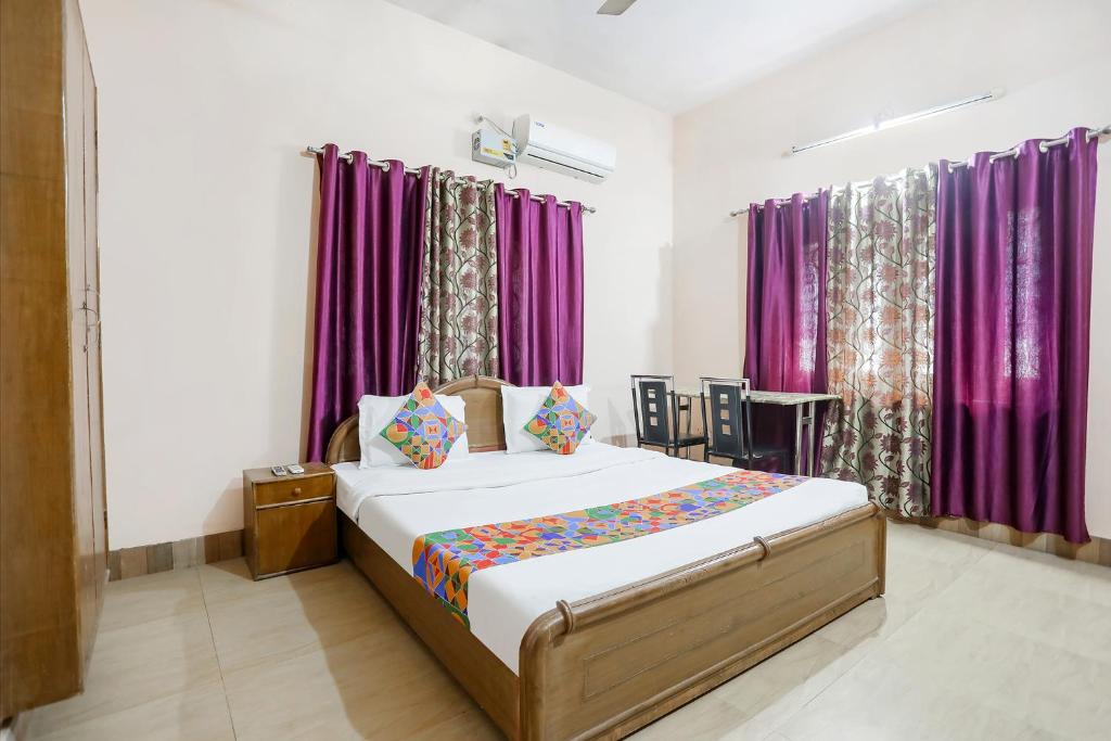 Schlafzimmer mit einem Bett mit lila Vorhängen in der Unterkunft FabExpress Corporate Stays in Ranchi