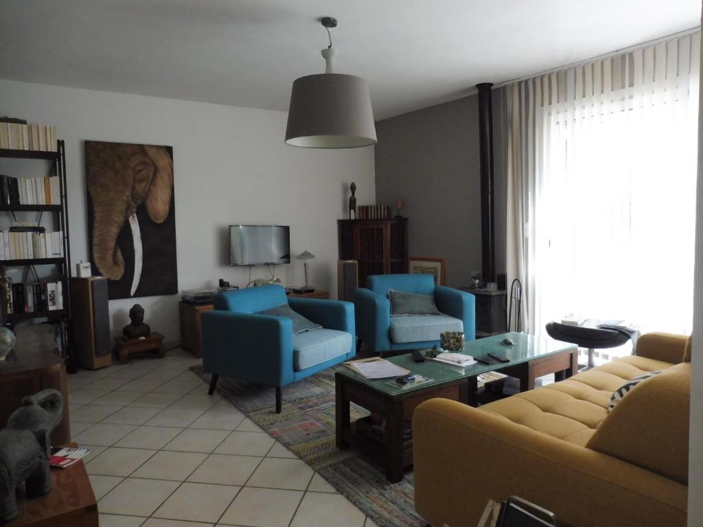 ein Wohnzimmer mit 2 blauen Stühlen und einem Tisch in der Unterkunft art Lançon in Lançon-Provence