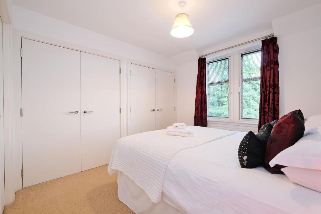 a white bedroom with a bed and a window at Lovely Aberdeen Home close to the Scottish Coast in Aberdeen