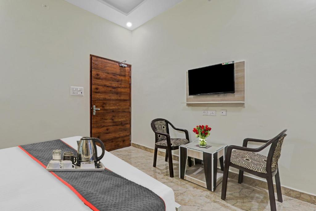 a hotel room with a bed and a table and chairs at Townhouse 1160 P.s.Palace Near Amausi Metro Station in Lucknow