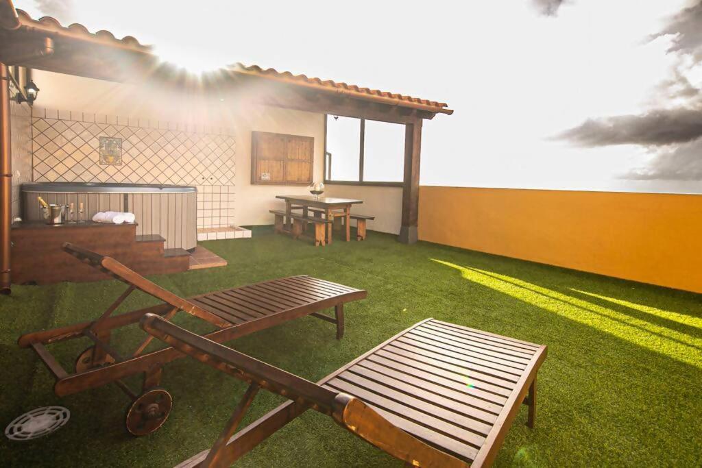 une terrasse avec une table de pique-nique, une table et des bancs dans l'établissement Precioso ático con vistas al mar, à Santa Úrsula