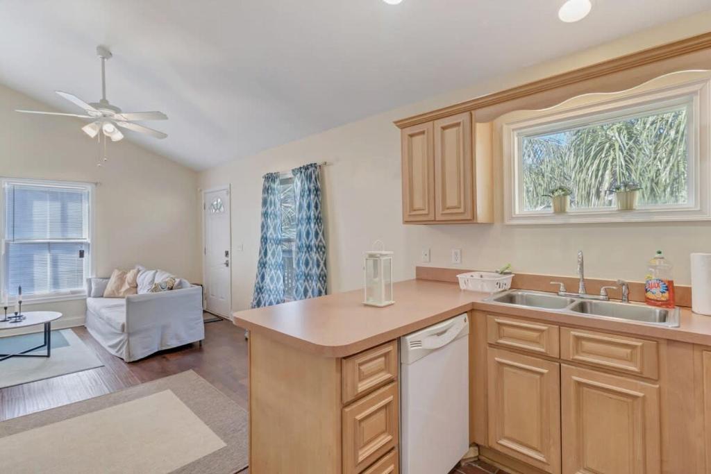 a kitchen with a sink and a living room at Large 1 BR carriage house in historic SPR in Jacksonville