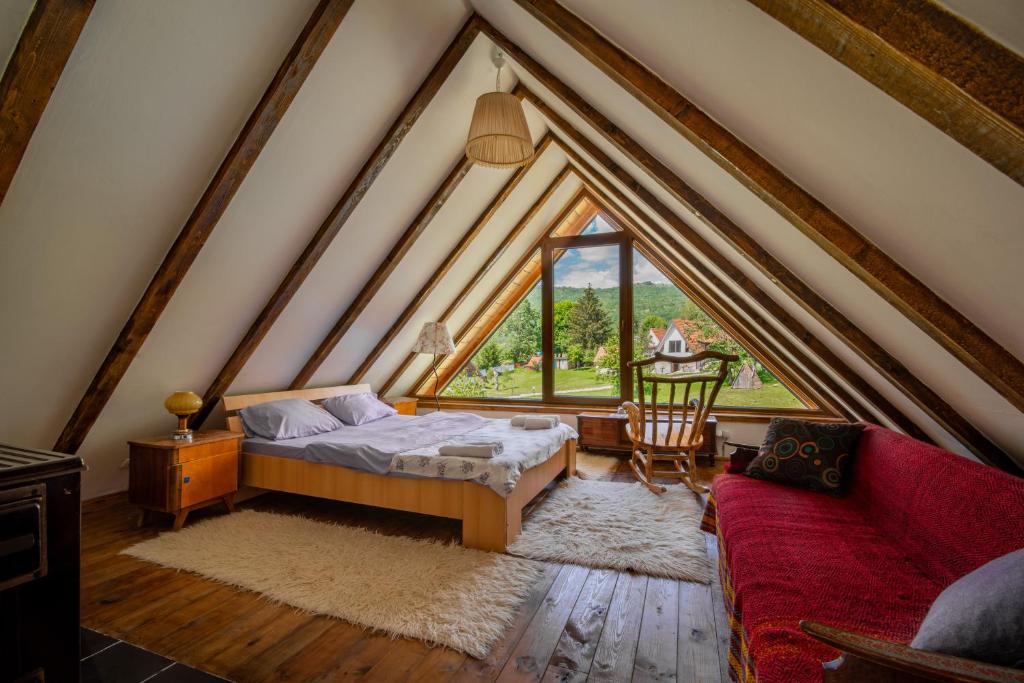 a attic bedroom with a bed and a couch at Ethno village Montenegro Brezna in Pluzine