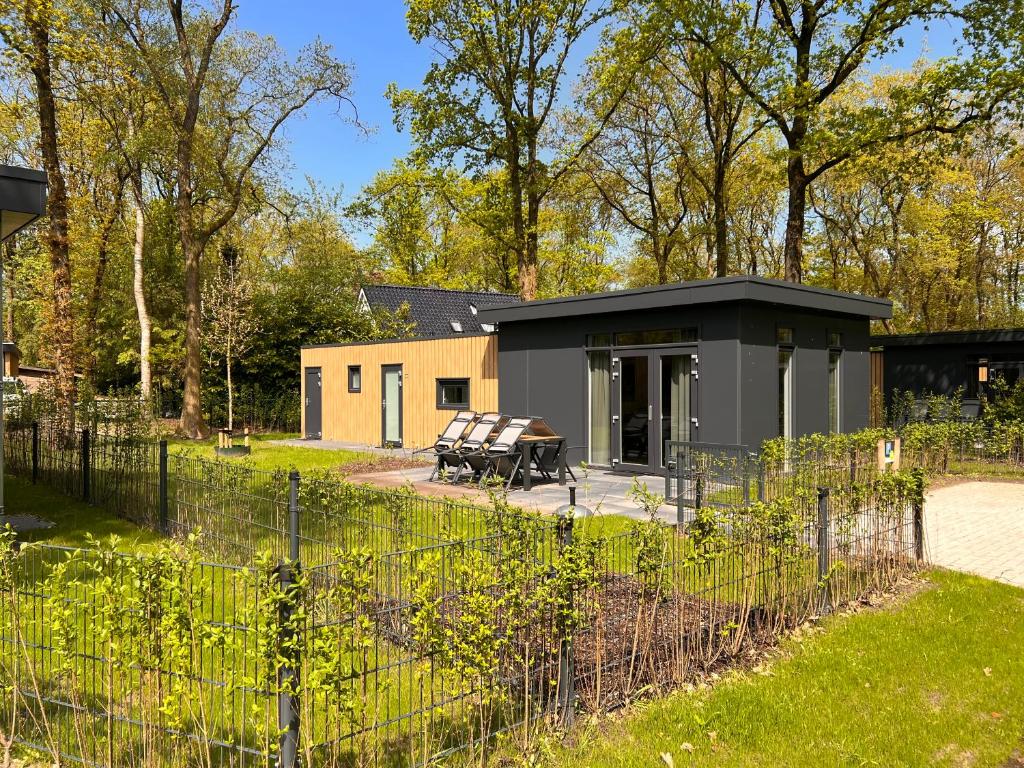 a black shed with a picnic table in a yard at Park Drentheland in Zorgvlied