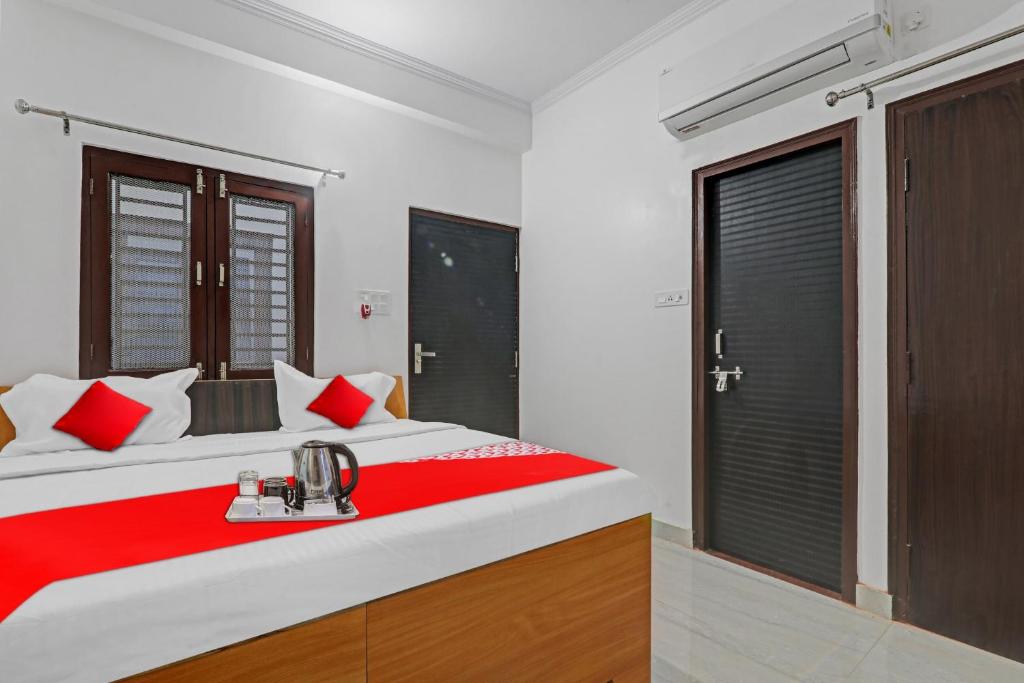 坎普爾的住宿－Flagship Sai Galaxy Hotel & Restaurant，一间卧室配有一张带红色毯子的大床