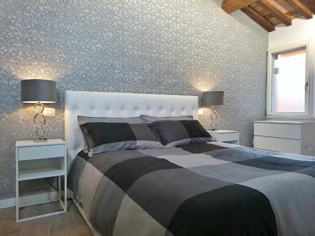 1 dormitorio con 1 cama con 2 mesitas de noche y 2 lámparas en Nel Cuore di Perugia, en Perugia
