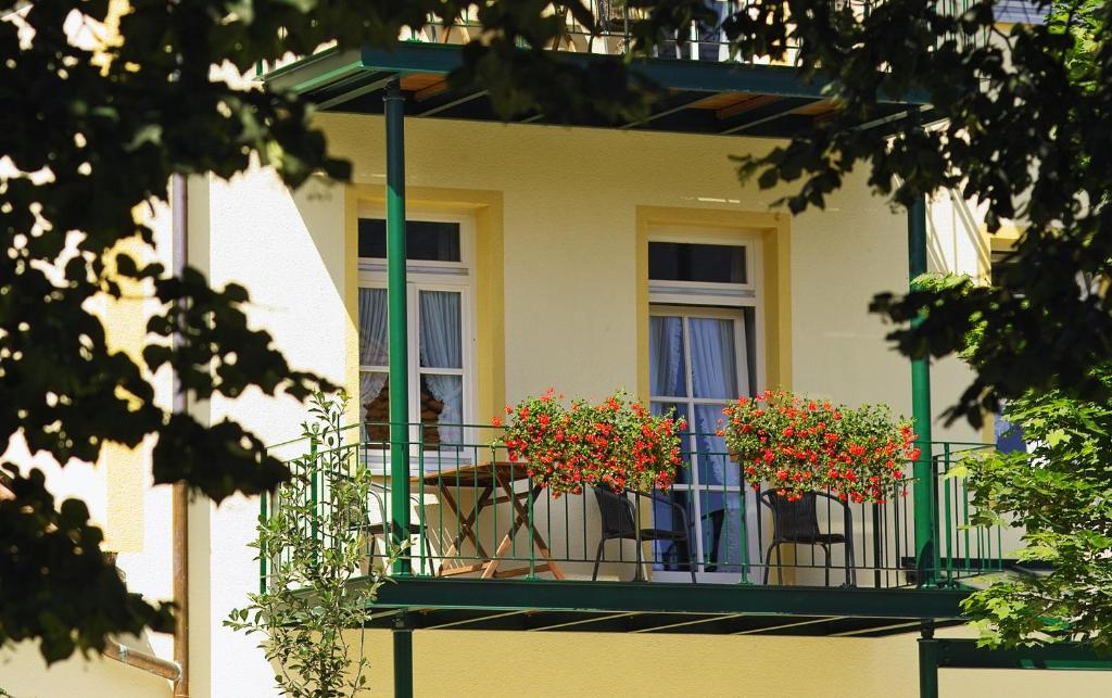 a balcony with a table and chairs and flowers on it at Ferienwohnungen am Rathaus in Ruhpolding