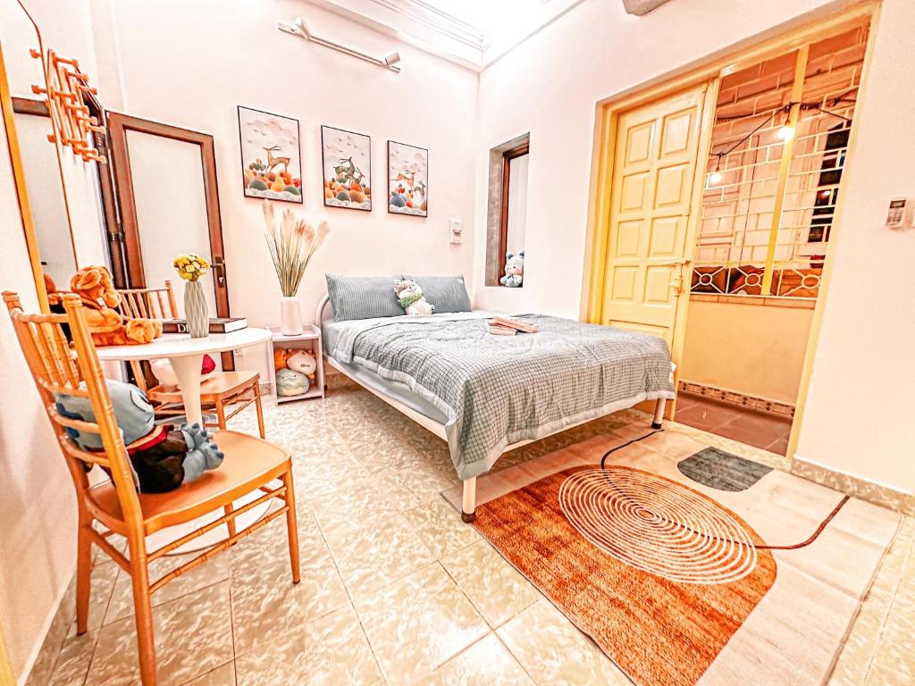 a bedroom with a bed and a table and a chair at La Casa Di Decembre 17/35 Nguyễn Như Đổ in Hanoi