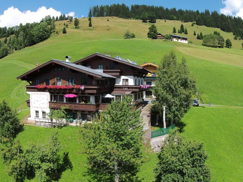 a house on a hill in a green field at Large Apartment in Maria Alm with Terrace in Maria Alm am Steinernen Meer