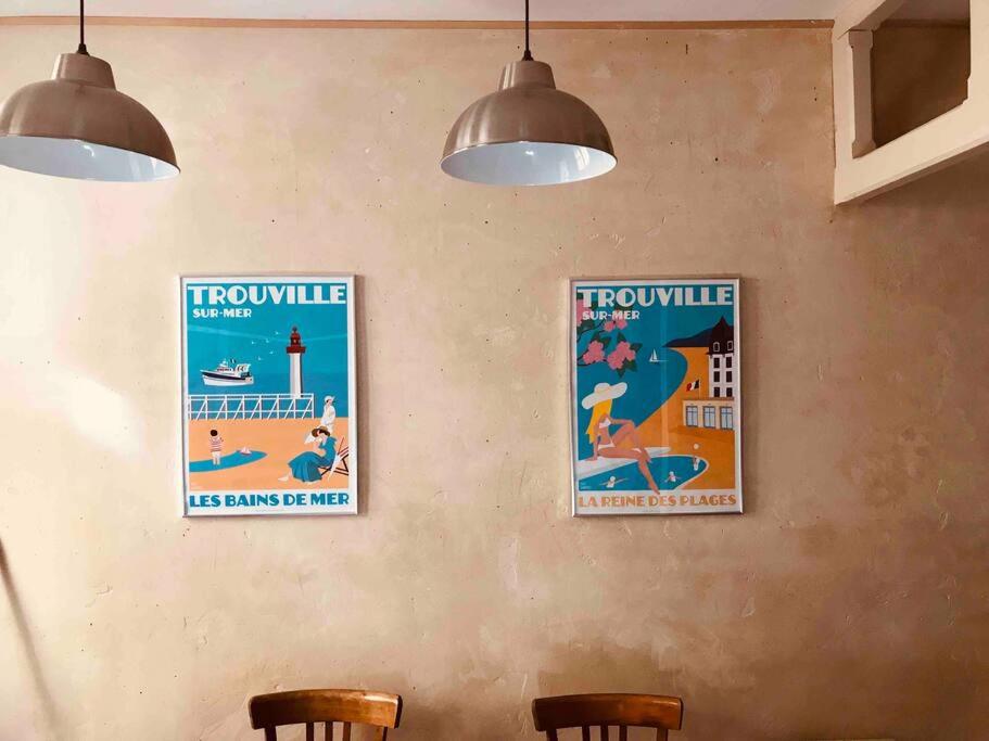 deux affiches sur le mur d'un restaurant dans l'établissement Maison de pêcheurs 2 chambres, proche de tout, à Trouville-sur-Mer