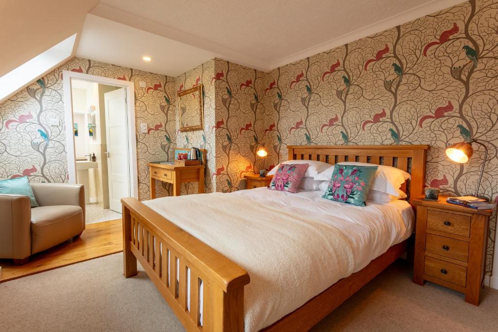 Eilean Donan Guest House في اولابول: غرفة نوم بسرير كبير وكرسي