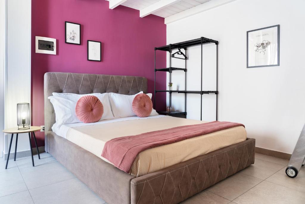 a bedroom with a large bed with purple walls at Ciuriddu Appartamenti in Castellammare del Golfo