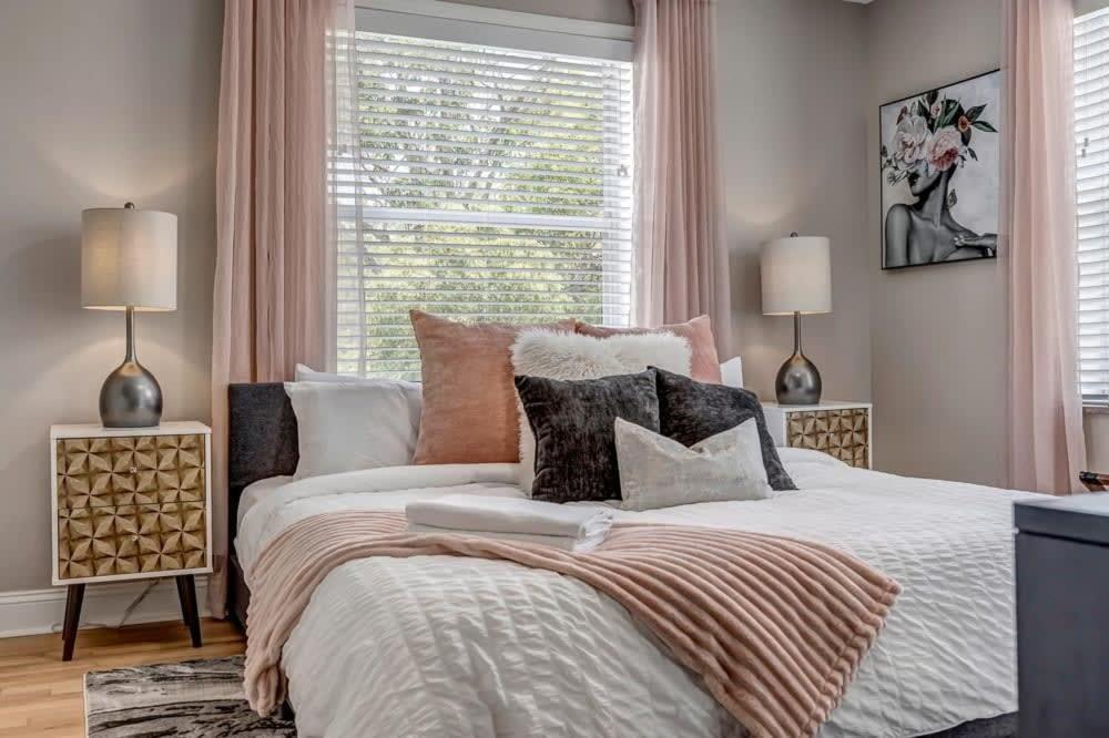 a bedroom with a bed with pillows and a window at Chic Waterfront Apartment in Downtown San Marco in Jacksonville