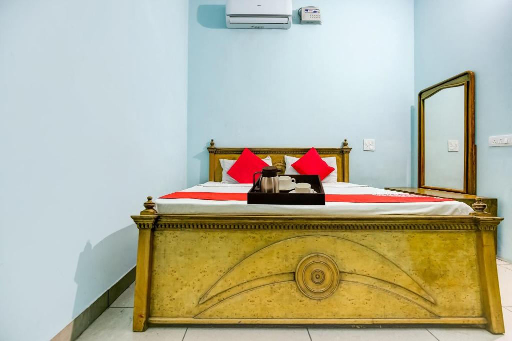 a bed with red pillows on it in a room at Flagship Moonlight Guest House in Patiāla
