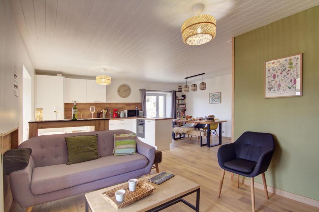 un salon avec un canapé et une table dans l'établissement L'orée du Mézenc et son bain nordique privatif, à Saint-Front