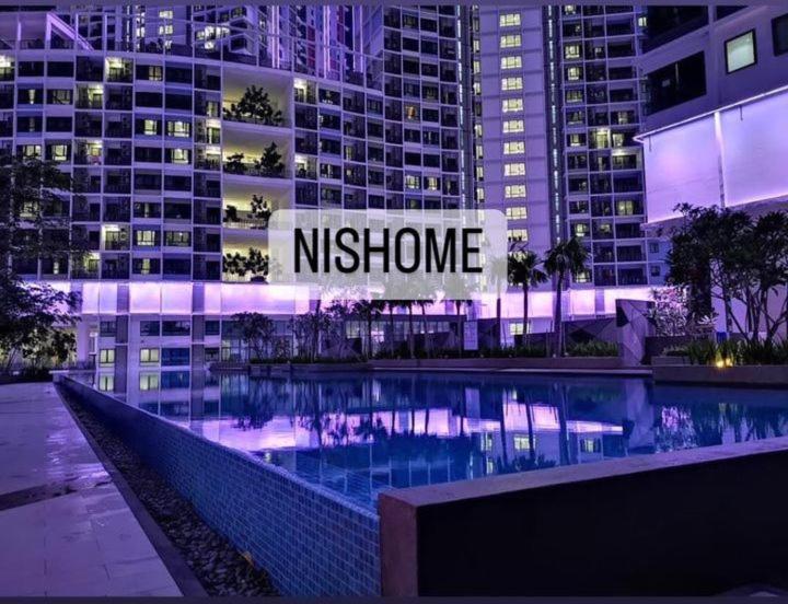eine nächtliche Aussicht auf ein Gebäude mit einem Pool in der Unterkunft homestay icity isoho shahalam-Nishome in Shah Alam