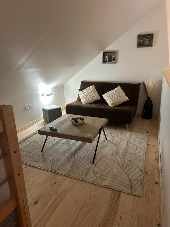 L’Escale du lac في Brêmes: غرفة معيشة مع أريكة وطاولة قهوة