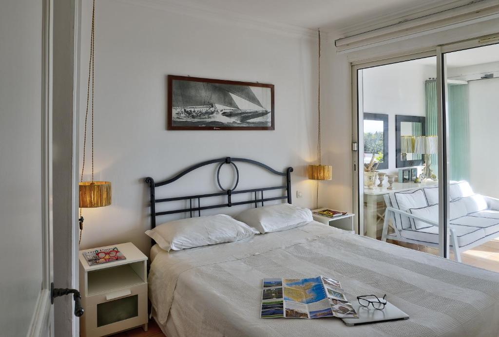 ein Schlafzimmer mit einem großen Bett und einem Balkon in der Unterkunft Les Bastides 3028 in Grimaud
