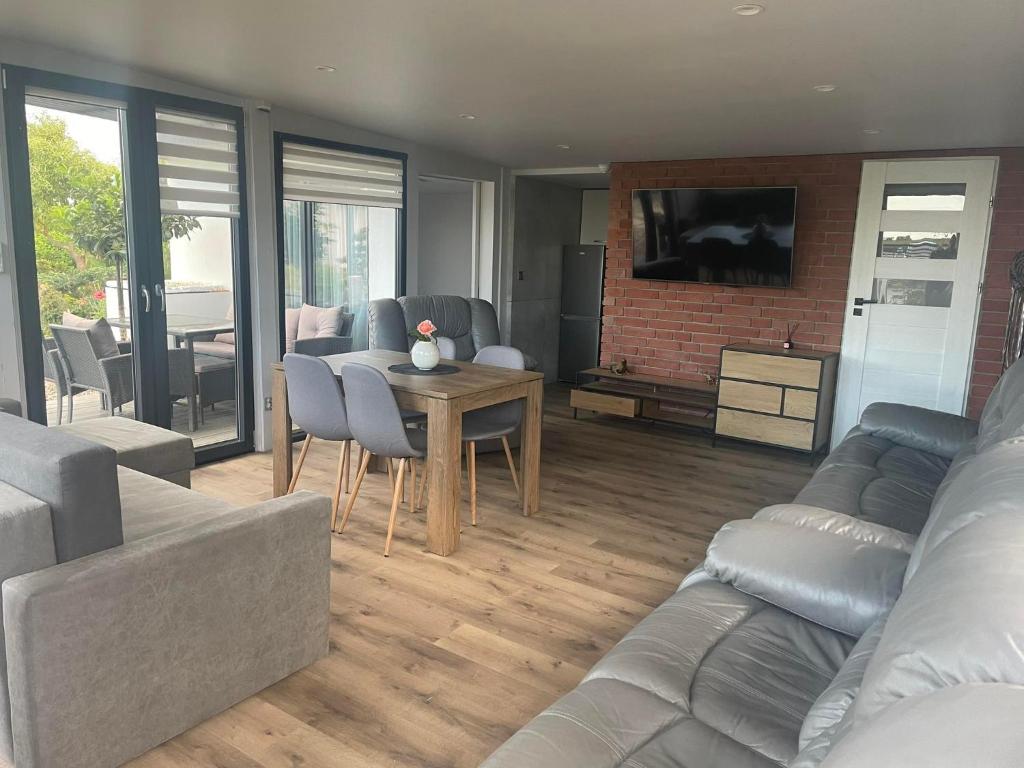 un salon avec un canapé et une table dans l'établissement Tęczowy Domek - Balia z hydromasażem, à Darłowo