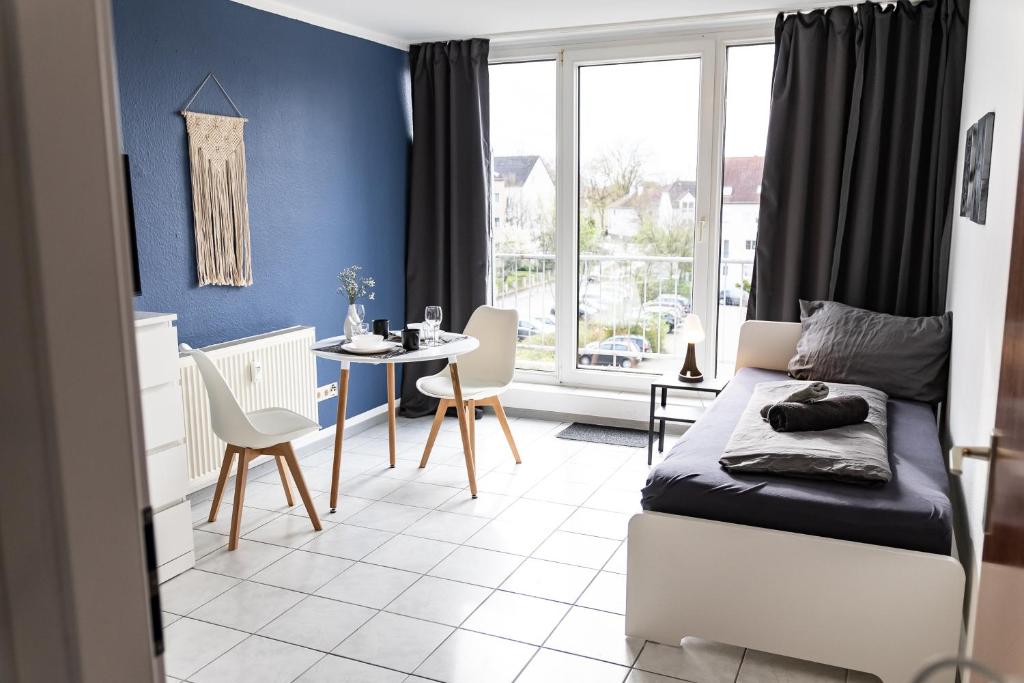 een slaapkamer met een bed en een tafel en stoelen bij Cosy 2 room apartment with balcony in Witten
