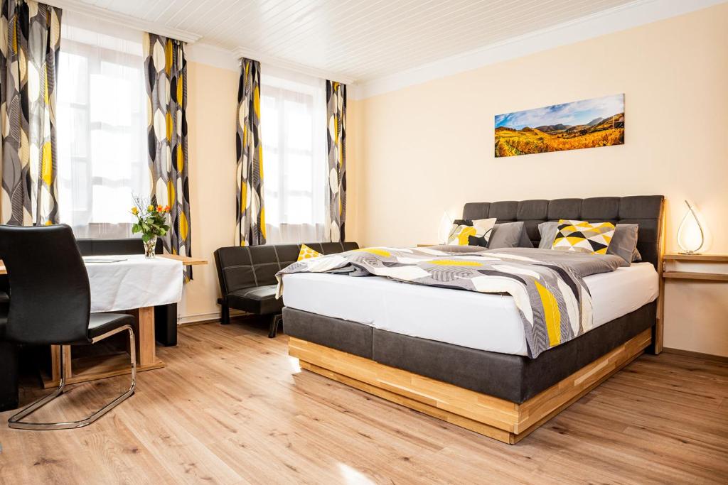 Schlafzimmer mit einem Bett, einem Tisch und Stühlen in der Unterkunft Gästehaus Bruckner in Spitz