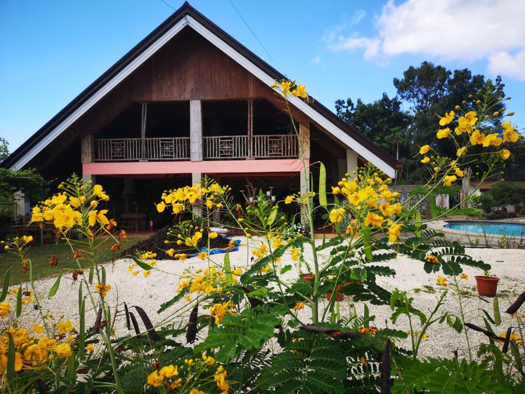 dom z żółtymi kwiatami przed nim w obiekcie Bossert Residence w Panglao City