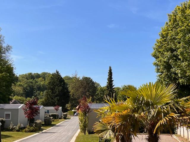 a residential street with houses and palm trees at Domaine du Blanc Pignon in La Calotterie