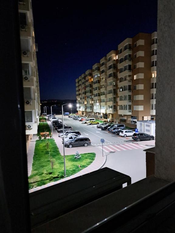 - une vue depuis la fenêtre d'un parking la nuit dans l'établissement Fiald Apartament nou, à Bacău
