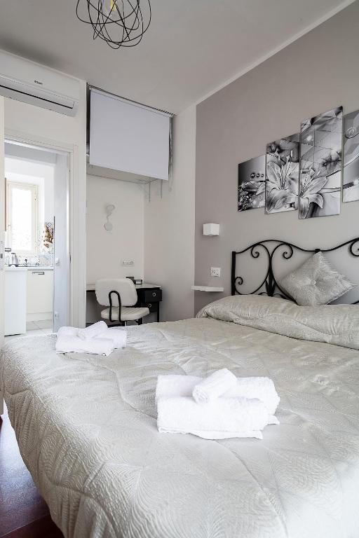 a bedroom with a large bed with towels on it at Casa di Ale in Tivoli