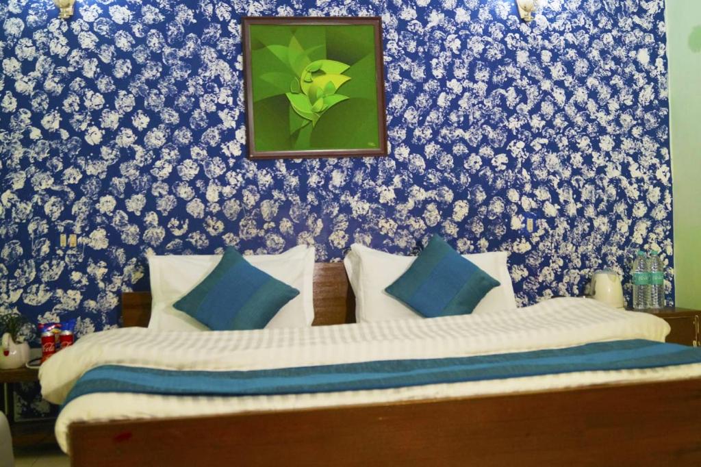 a bedroom with a bed with blue and white wallpaper at Hotel HRS - New Delhi Railway Station in New Delhi