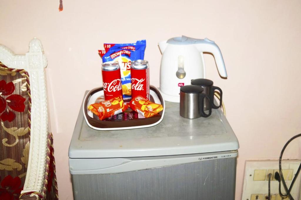 a counter with chips and snacks on top of a refrigerator at Hotel HRS - New Delhi Railway Station in New Delhi