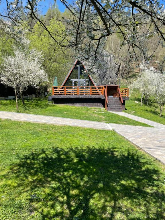 un parque infantil con árboles y césped en Valea Mosului - Cozy A Frame, en Petroşani