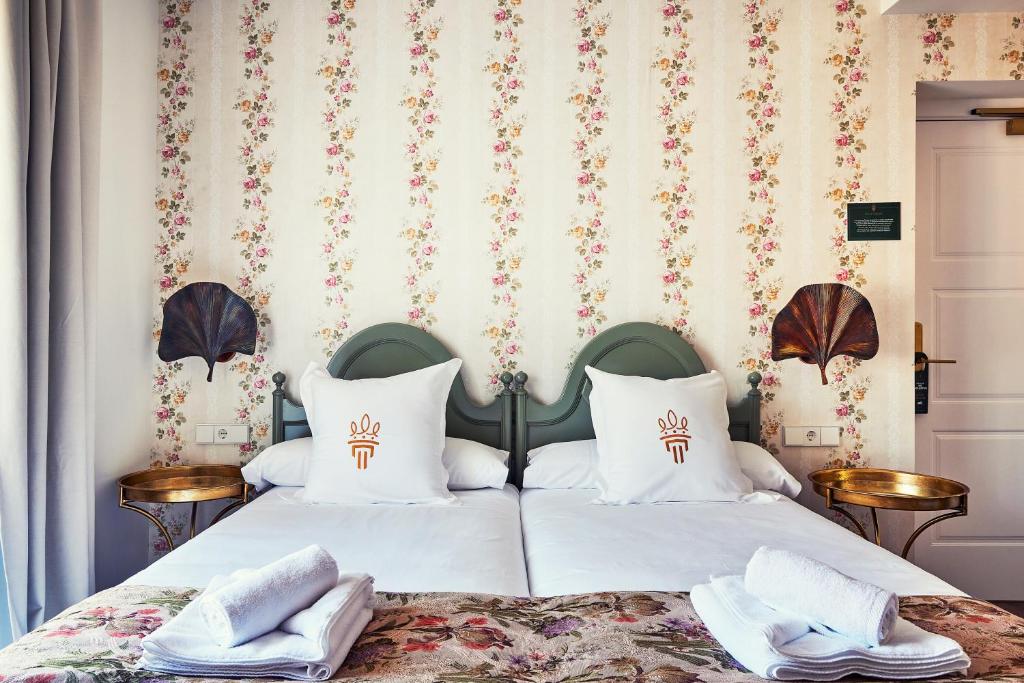 a bedroom with two beds with white pillows at Casa Palacio Reina de Tardajos in Vinuesa