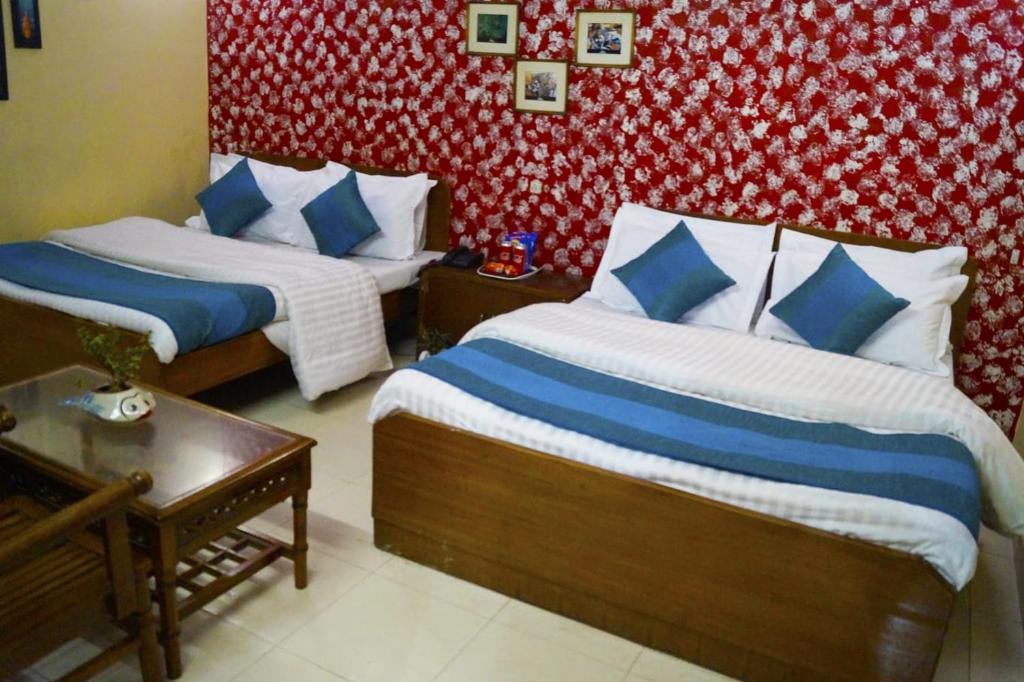 a bedroom with two beds with blue and white pillows at Hotel HRS - New Delhi Railway Station in New Delhi