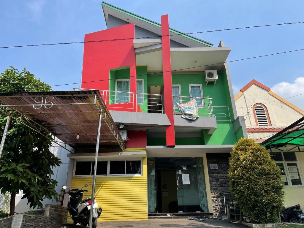 uma casa colorida com uma scooter estacionada em frente em SPOT ON 93853 Budi Residence 2 em Bekasi