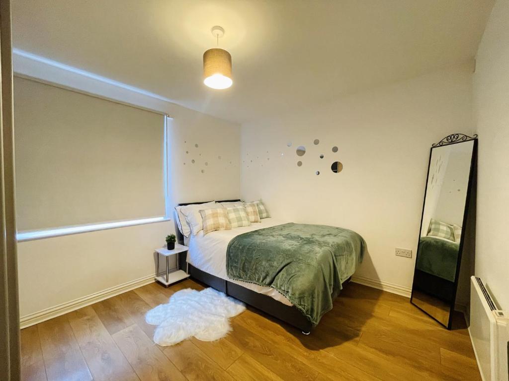 - une chambre avec un lit, un miroir et un tapis dans l'établissement Starberry Court, à Londres