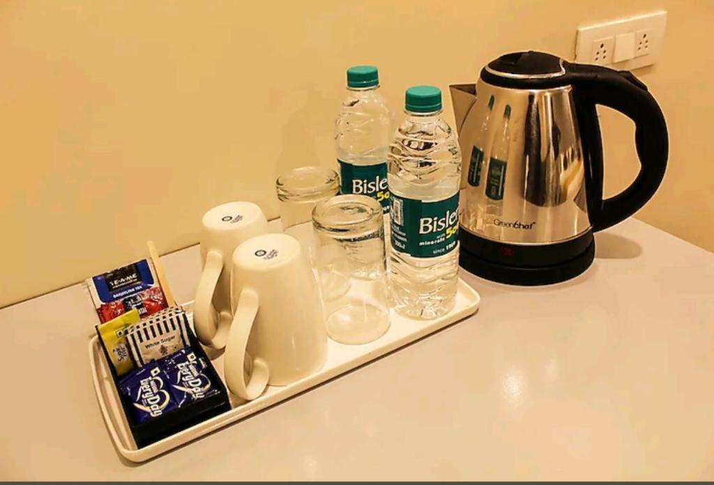 a tray with bottles of water and a tea kettle at Hotel HRS - New Delhi Railway Station in New Delhi