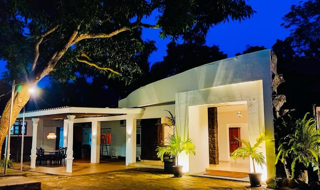 ein weißes Haus mit einer Veranda in der Nacht in der Unterkunft Sima's Cottage in Anuradhapura