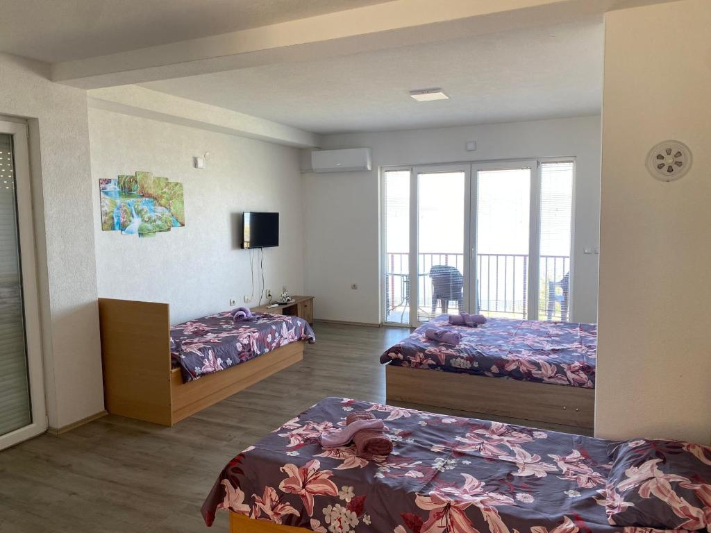 a hotel room with two beds and a balcony at RISTESKI GUEST HOUSE in Ohrid