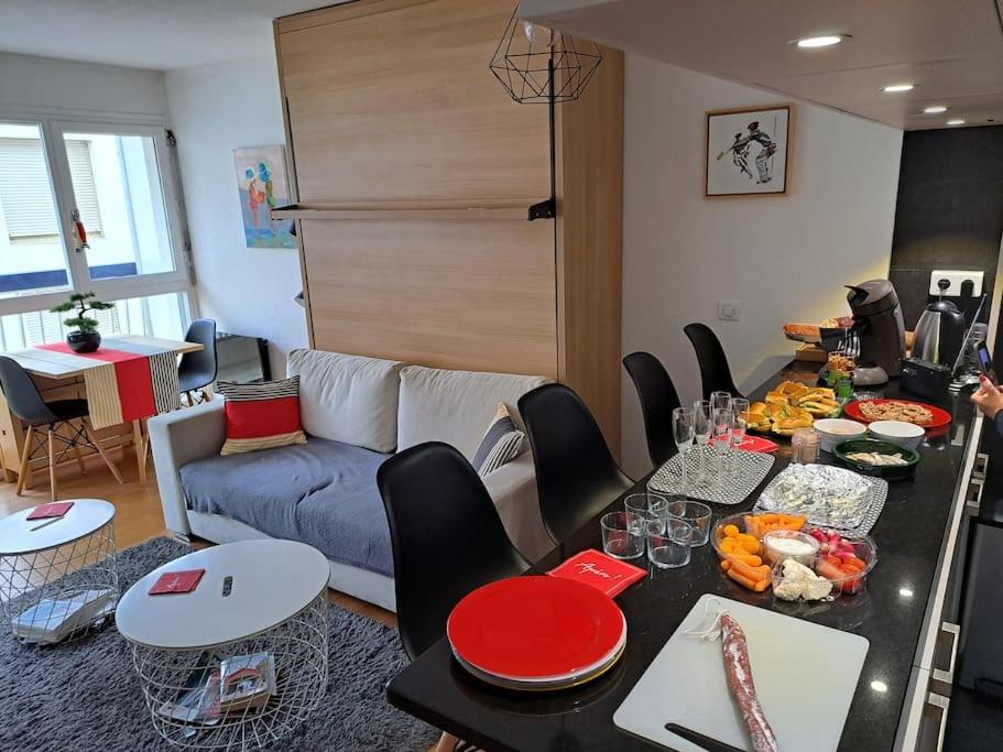 ein Wohnzimmer mit einem Tisch und einem Sofa in der Unterkunft Le Vauban avec les cles de Luz in Saint-Jean-de-Luz