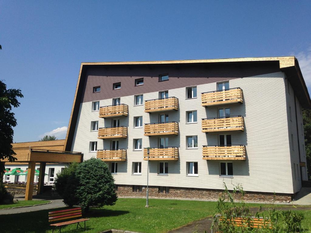 a large building with balconies on the side of it at Hotel Srní depandance - Šumava in Srní