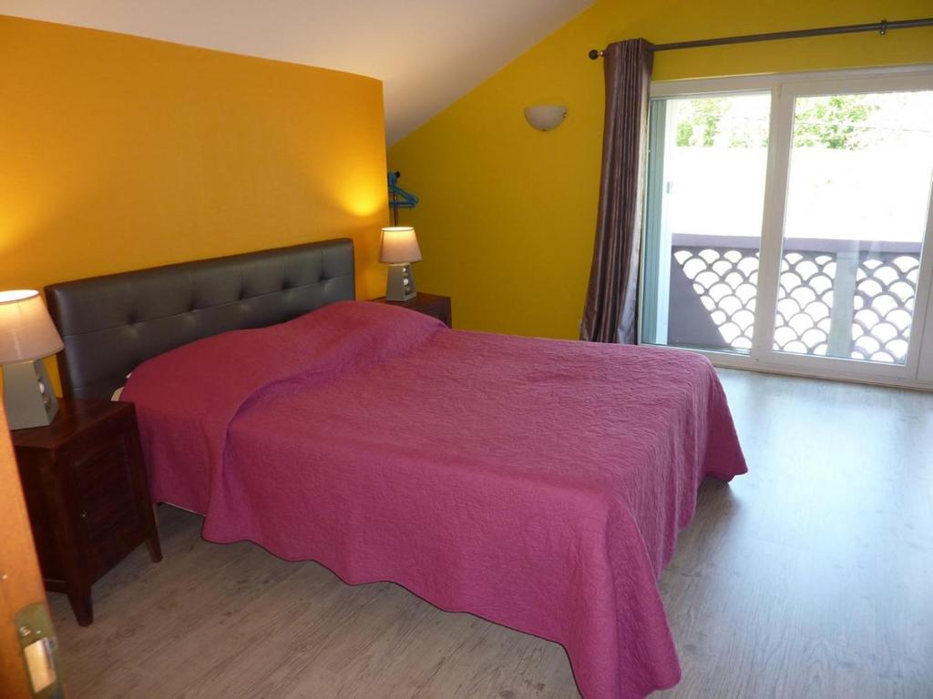 VILLA CHANTAL في فردان سور ميوز: غرفة نوم بسرير وبطانية وردية