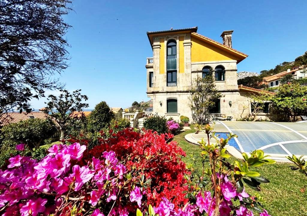 um edifício com um ramo de flores à frente dele em Holibai, Vila Arume, Sofisticación y Confort cerca de Baiona em Pontevedra