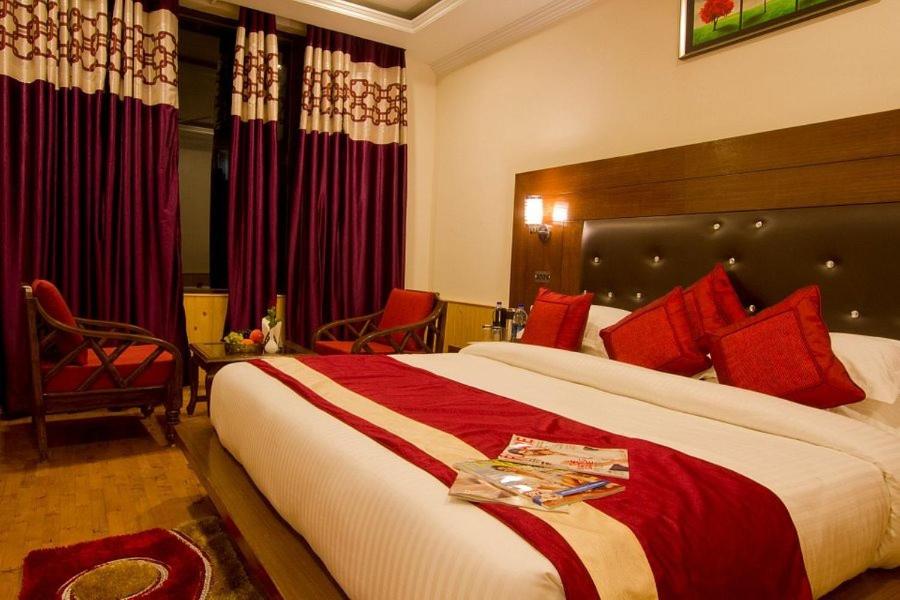 a hotel room with a large bed with red pillows at Hotel HRS - New Delhi Railway Station in New Delhi