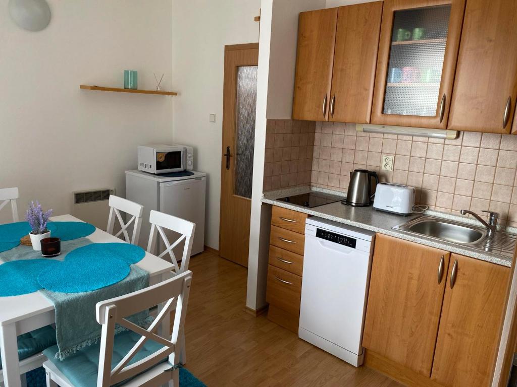 a small kitchen with a table and a sink at Apartmán Diana in Oščadnica
