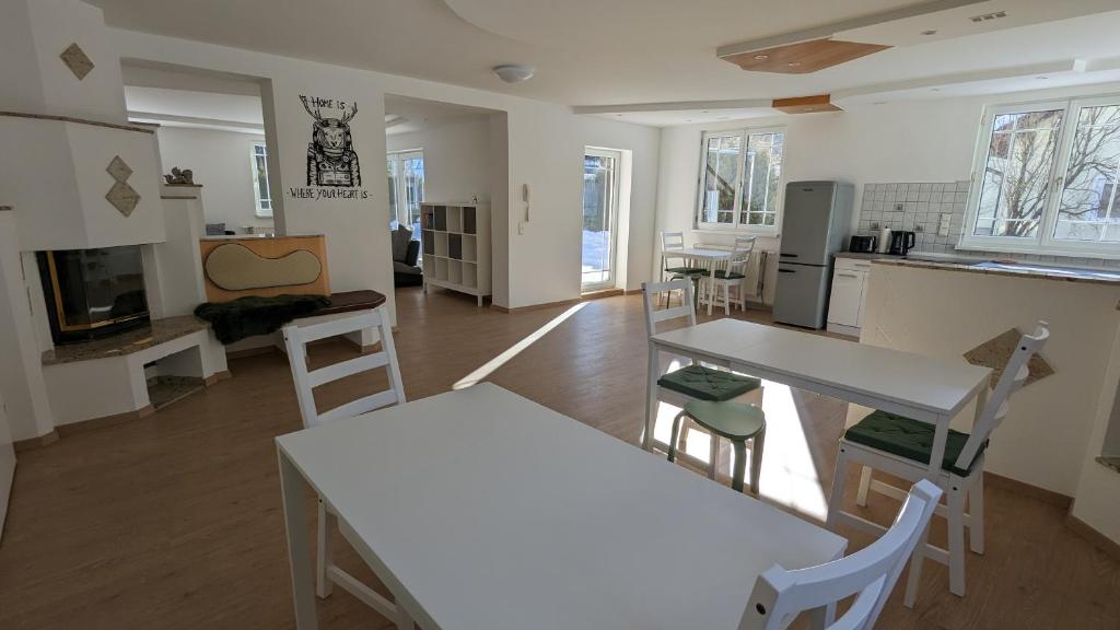 a kitchen with white tables and chairs in a room at Wülde Hoamat in Eisenerz