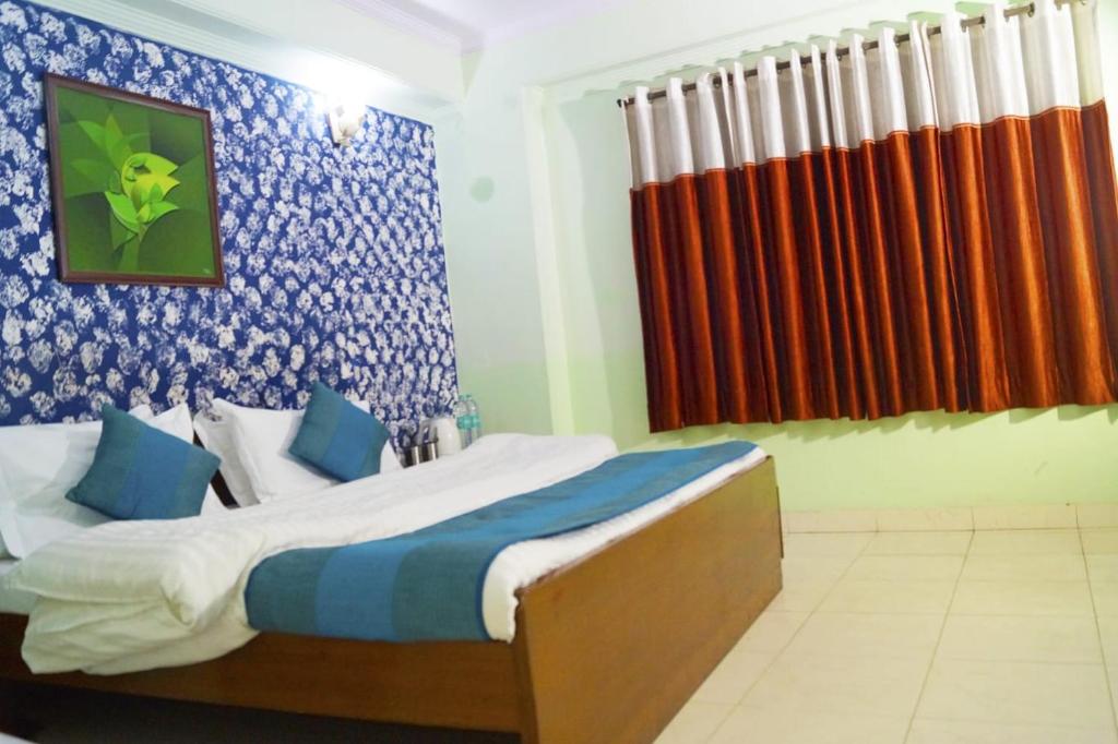 a bedroom with a bed with a blue and orange curtain at Hotel HRS - New Delhi Railway Station in New Delhi