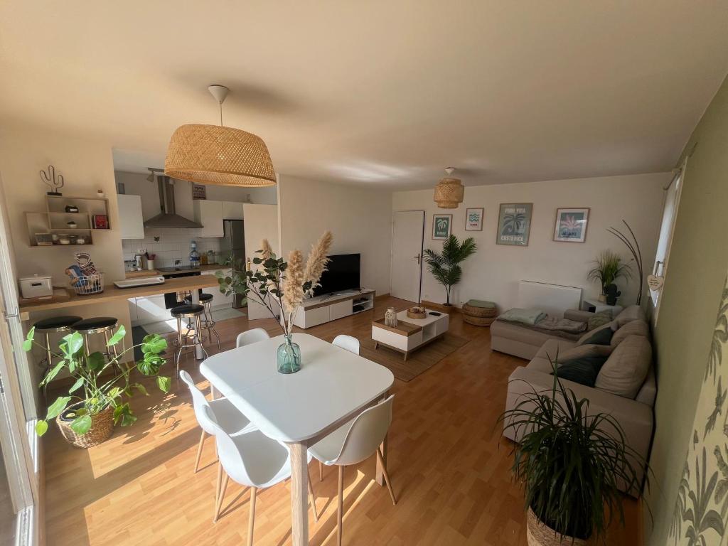 un salon avec une table et des chaises blanches dans l'établissement Appartement 6 personnes Lille, à Lille
